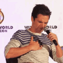 a man is holding a microphone and giving a thumbs up sign