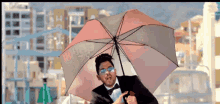 a man in a tuxedo holds an umbrella in front of a roller coaster that says ' winner ' on it