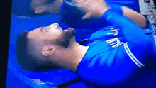 a blue jays player is laying down on the field