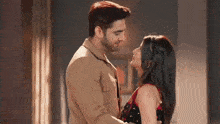 a man and a woman are standing next to each other and kissing .