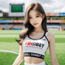 a woman wearing a sbobet top stands on a field