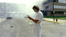 a man in a nurse 's uniform is standing in front of an emergency entrance
