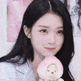 a woman is holding a stuffed animal that has a peach hat on it