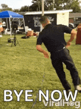 a man in a black shirt is dancing in a field with the words bye now viralhog below him