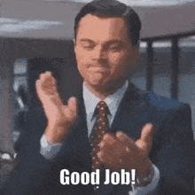 a man in a suit and tie is applauding and saying `` good job '' .