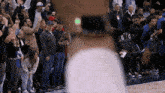 a crowd of people watching a basketball game with the letters gg on the bleachers