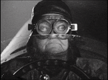 a black and white photo of a man wearing a helmet and goggles with burg written on the lenses