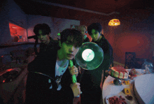 a group of young men are standing around a table with plates of food and a cake with the number 6 on it