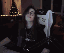 a man and a woman are dancing in front of a microphone with a christmas tree in the back