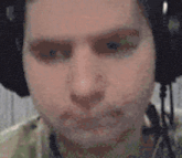 a close up of a man wearing headphones and making a face .