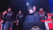 a group of thieves players holding a trophy in their hands