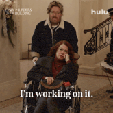 a poster for only murders in the building shows a woman in a wheelchair and says i 'm working on it