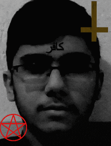 a man wearing sunglasses has a cross on his forehead with arabic writing
