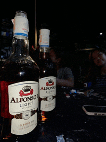 two bottles of alfonso light alcohol are sitting on a table