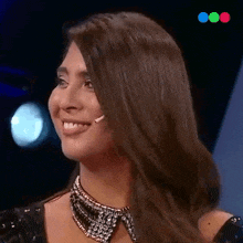 a woman wearing a necklace with rhinestones on it smiles