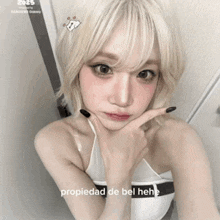 a woman with blonde hair is taking a selfie and the caption says " propiedad de bel hehe "
