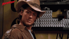 a man wearing a cowboy hat with the word baywatch on the bottom