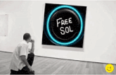 a man sitting in front of a painting that says free sol