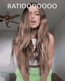 a woman with long hair sticks her tongue out in front of a ceiling fan and the words ratiooo00000