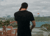 a man in a black shirt is talking on a phone