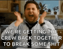 a man in a tie is screaming in a kitchen and saying we 're getting the crew back together to break some shit
