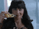a woman with long black hair is eating a piece of cake