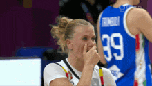 a female basketball player wearing number 39 covering her nose