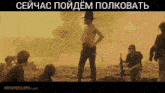 a man without a shirt is standing in front of a group of soldiers with movieclips.com in the corner