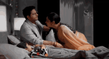 a woman kisses a man on the forehead while a child lays in bed