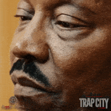 a close up of a man 's face with trap city written on the bottom