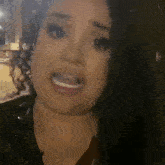 a woman with curly hair is making a funny face while smoking a cigarette .