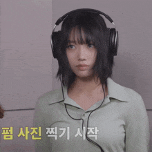 a woman wearing headphones giving a peace sign in korean