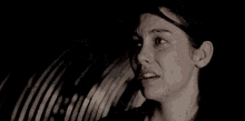 a man is kissing a woman 's forehead in the dark .