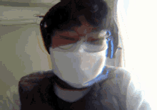 a person wearing a face mask and glasses looks at the camera