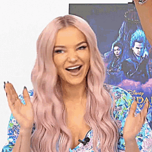 a woman with pink hair is smiling in front of a poster for descendants 3