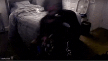 a person is laying on a bed in a dark room with a fan .