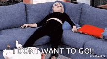 a woman is laying on a couch with the words `` i don t want to go '' written on the bottom .