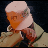 a person is wearing a hat that says pet lers on it
