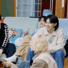 a group of young people are sitting on a couch and one of them is pointing up