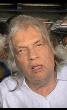 a man with long grey hair making a funny face