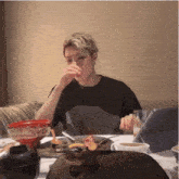 a man is sitting at a table with a plate of food and a cup of coffee