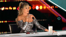 a woman sitting at a table with a dunkin donuts cup