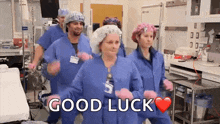 a group of nurses and doctors are dancing in an operating room with the words `` good luck '' written on the bottom .