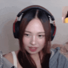 a woman wearing headphones is sitting in front of a computer screen .