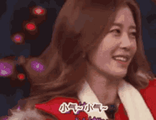 a woman wearing a santa hat is smiling with chinese writing on her face