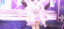 a girl in a white dress is dancing on a stage with a purple background .