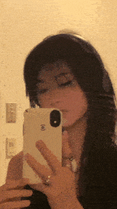 a woman is taking a picture of herself in the mirror with her phone