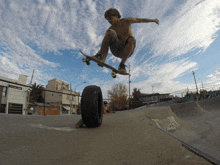 a skateboarder is doing a trick over a tire
