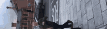 a man is doing a trick on a skateboard on a sidewalk in front of a building .