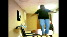 a woman in a black shirt and blue pants is jumping in the air